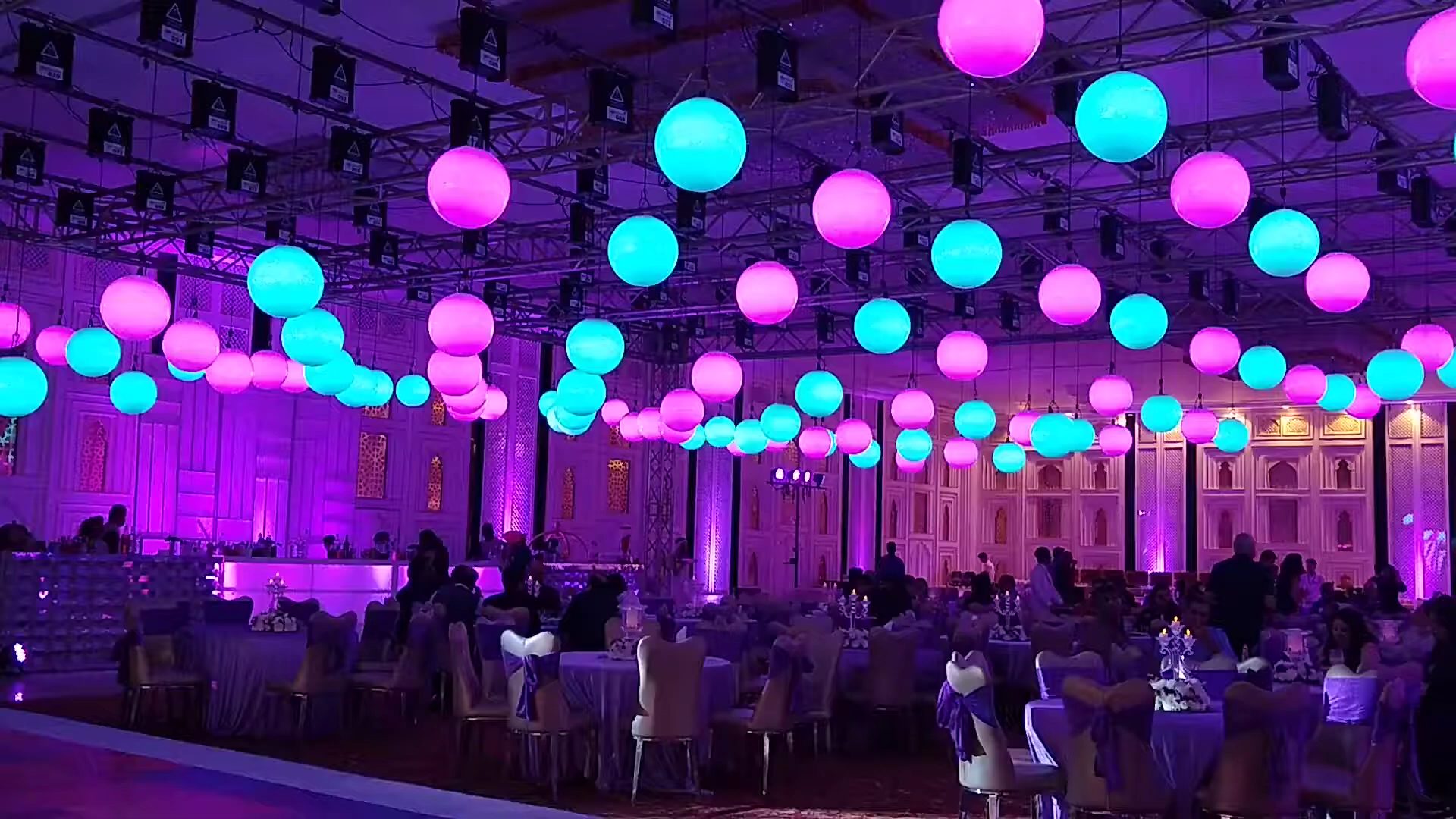 An event room transformed by colorful suspended kinetic lighting